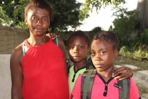 Jeunes du CAEJ-Haïti avec leur maman et leurs effets scolaires